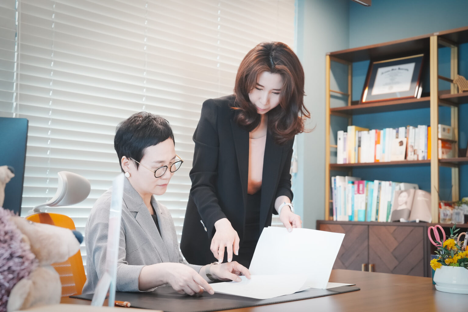 원장님과 최정아 대표가 책상에서 함께 서류를 살펴보는 모습